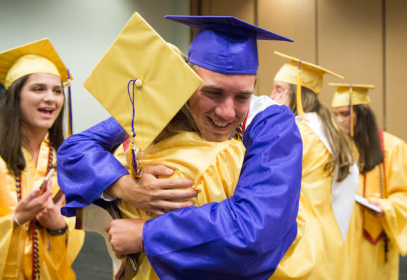 High school graduates hugging