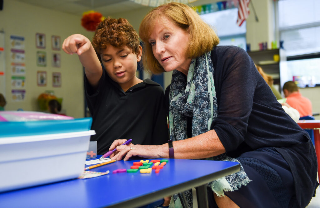 Debbie Baker works with Desmond Hernandez, a 2nd-grader at Simmons Elementary, on building words with plastic letters.