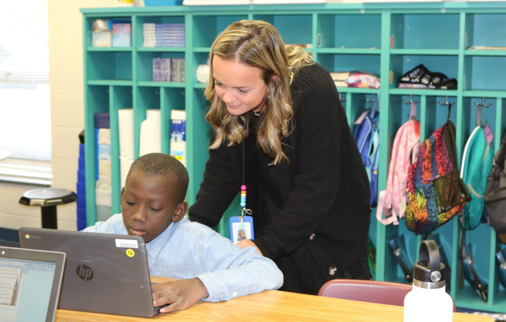 A teacher works one-on-one with a student.