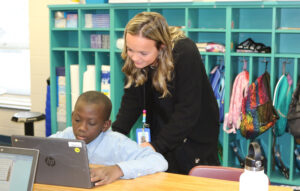 A teacher works one-on-one with a student.